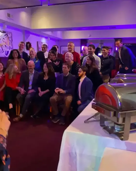 A company holiday party group photo at Midtown Social beside the buffet.