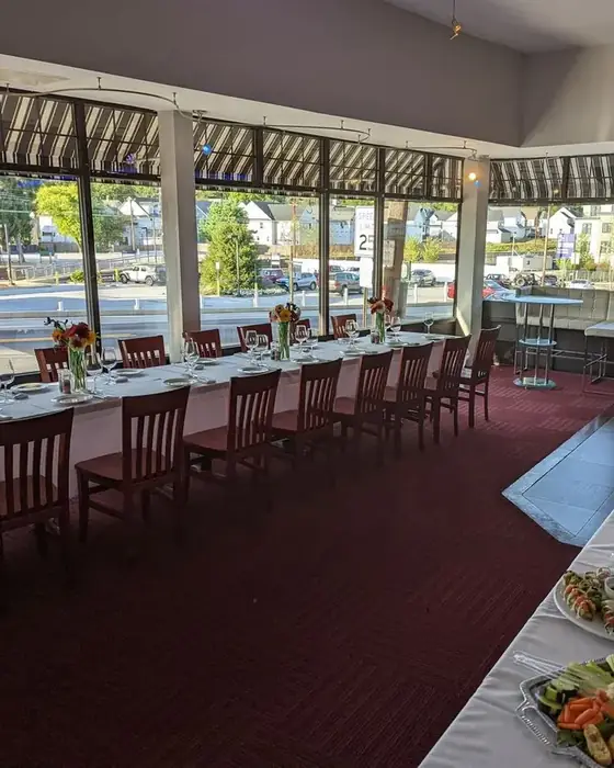 The first floor set for a daytime event, with a long table by the windows looking out to Berwyn station across Lancaster Avenue.