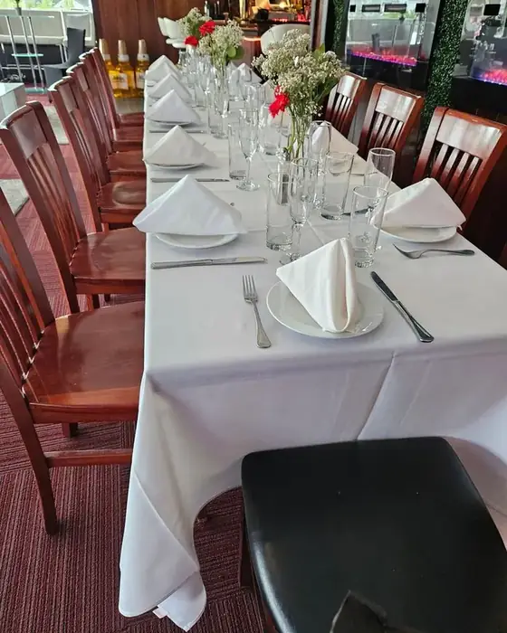 A long table set formally with white linen, glassware and flowers on the first floor at Midtown Social.