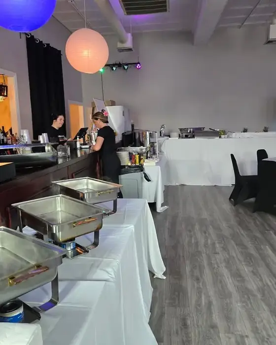 Chafing dishes set along the upstairs bar in Midtown Hall with staff serving a buffet.