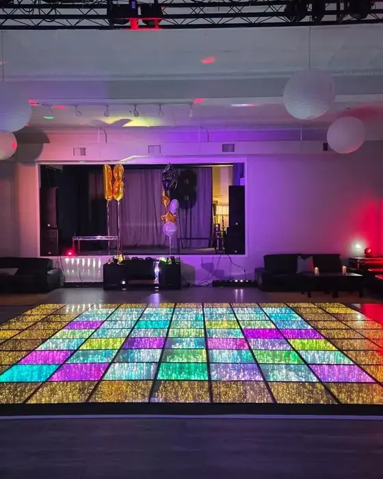 Midtown Hall with the LED dance floor lit in rainbow colours, lounge seating and the stage beyond.