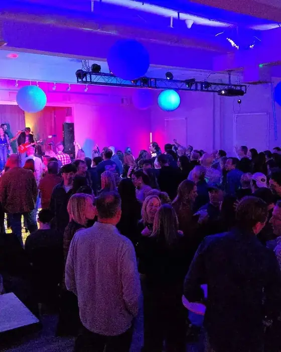 Midtown Hall packed with hundreds of guests watching a live band on stage.