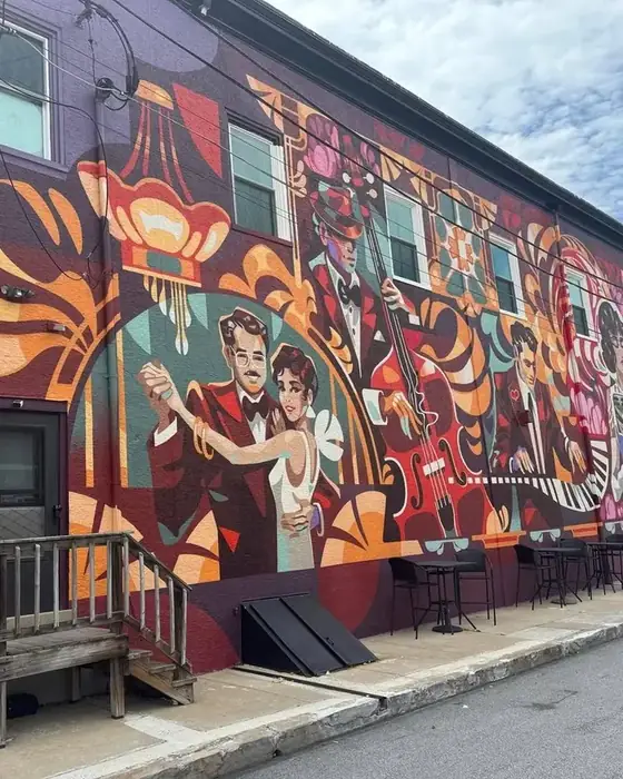 The Main Avenue mural in Berwyn showing a dancing couple and a double bass player painted in purple, orange and teal.