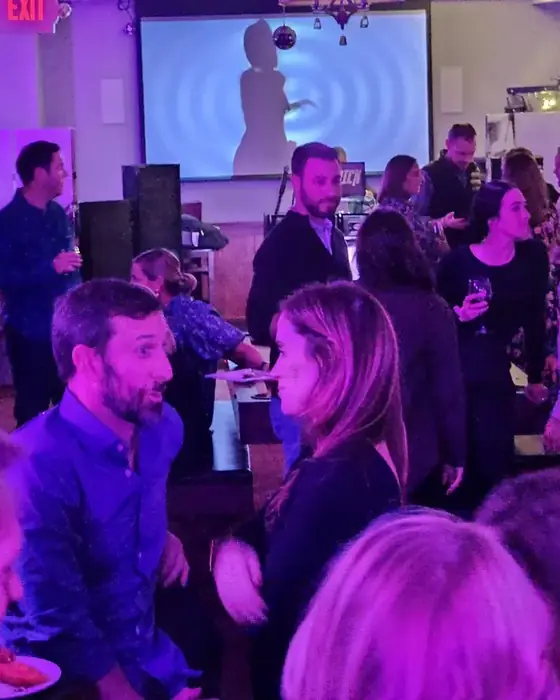 A private party in full swing with a DJ, projection screen and buffet.